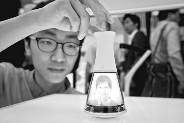 图为本科三年级的黄恺宇展示可以跨越时空实现亲子沟通的“全景视频电话”。